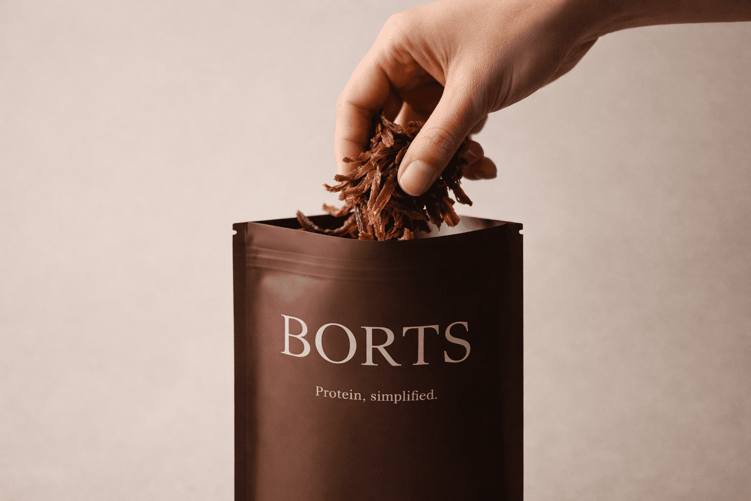 Hand grabbing BORTS beef shavings from the bag